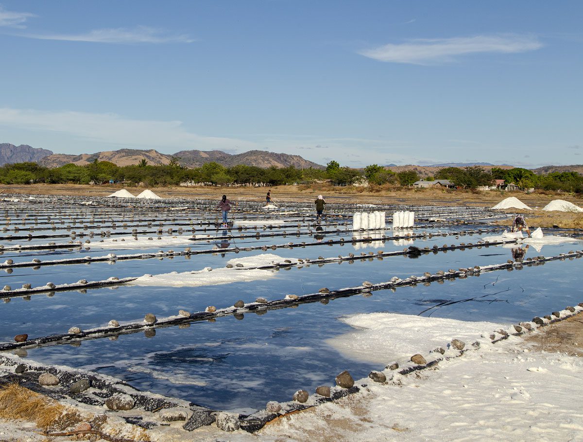 Workers at shallow evaporation pools collecting salt.