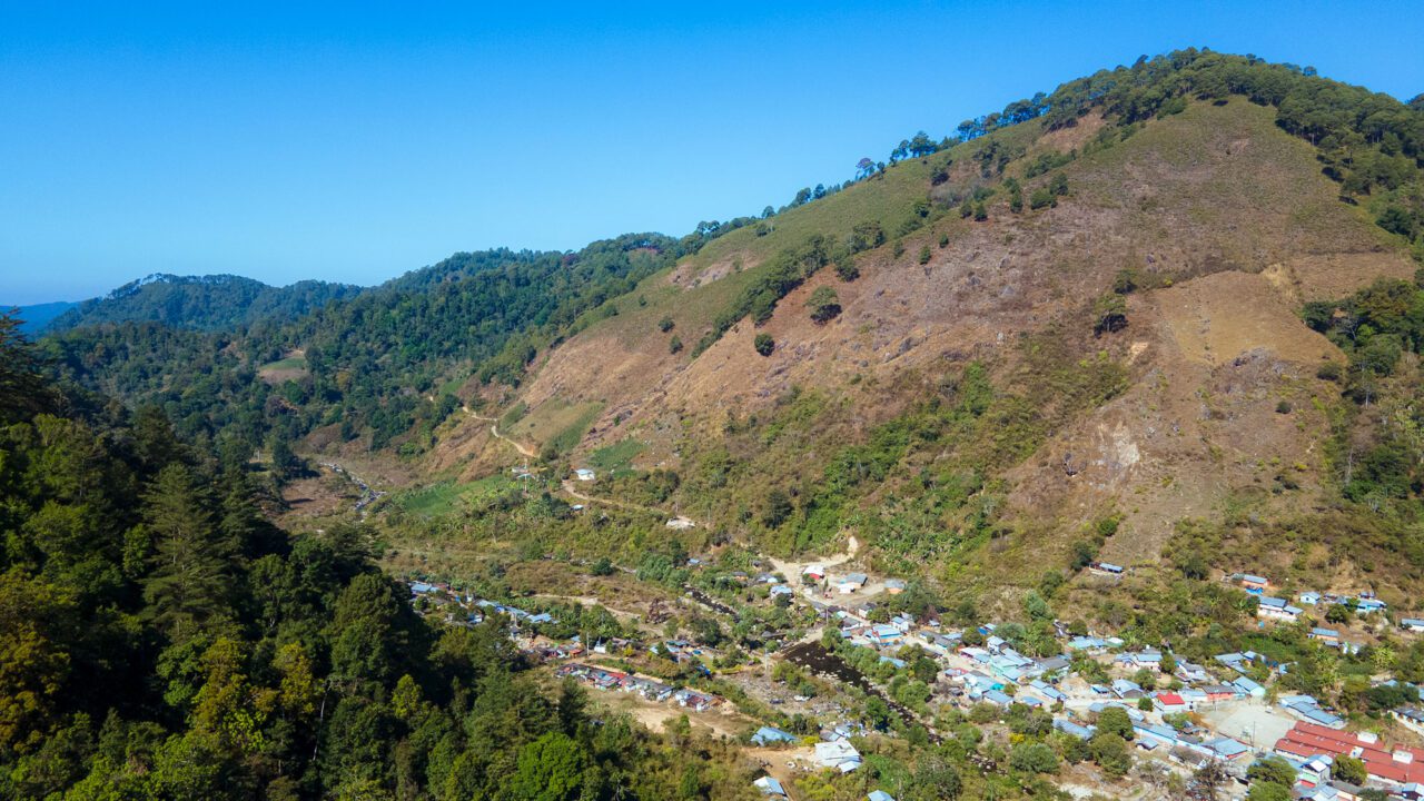 A barren hillside with buildings at the bottom.