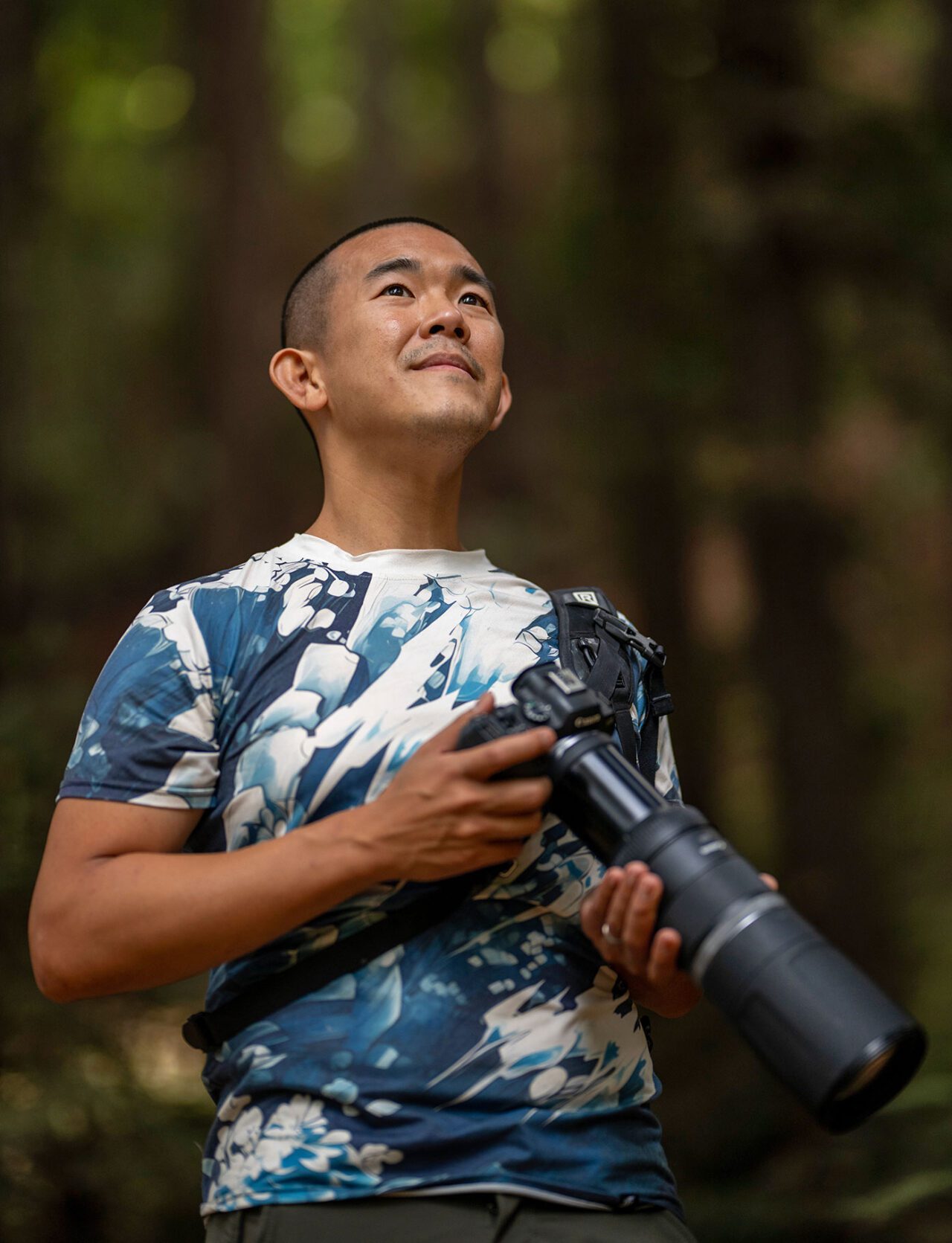 A man stands with a camera.